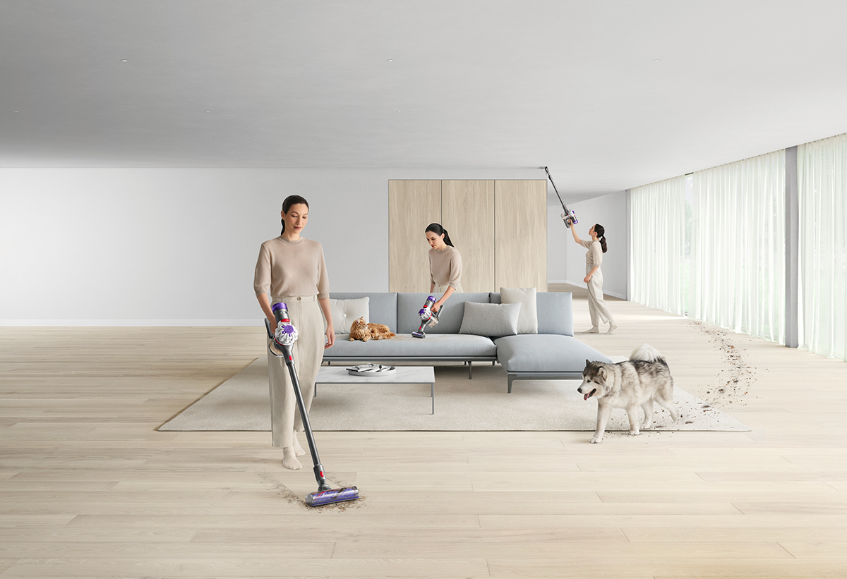 Απεικονίζεται γυναίκα να καθαρίζει σε όλο το σαλόνι με έναν σκύλο δίπλα να κάνει πατημασιές.